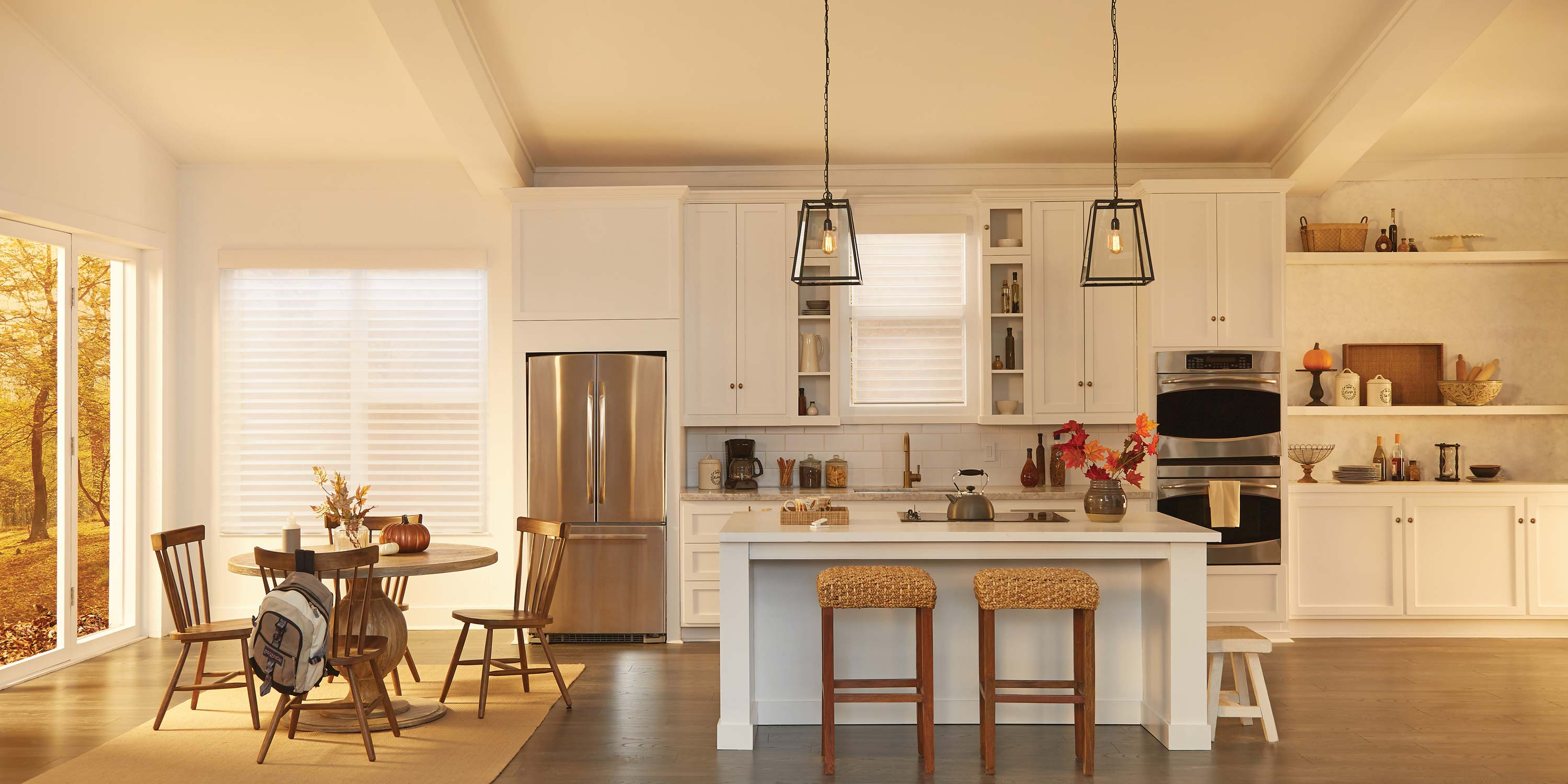 Warm kitchen, fridge, fall scene, white cabinets, wooden table and chair